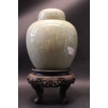 A DARK GREEN CELADRON GINGER JAR WITH LID, having a brown rim, no mark beneath, sitting on a