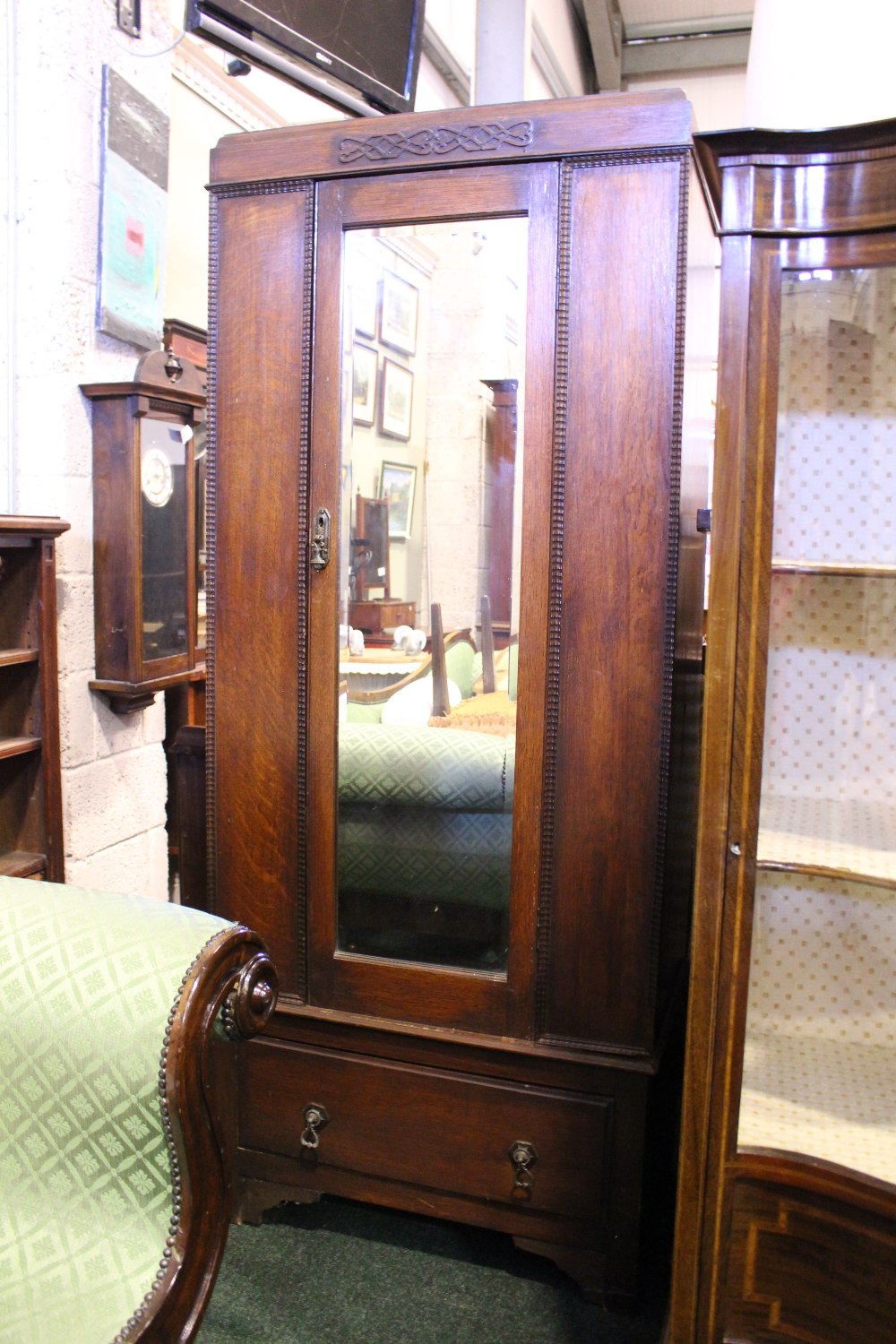 AN EARLY 20TH CENTURY OAK 1 DOOR WARDROBE, with bevelled mirror panel, carved details on a single