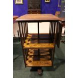 AN OAK SWIVEL BOOKCASE, early 20th century, with slated sides and cast iron centre poll, a single