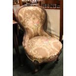 A LOW RISE BEDROOM / NURSING CHAIR, with carved rose detail to the frame, raised on short cabriole