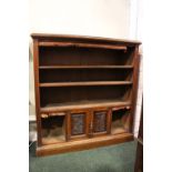 AN OAK OPEN FLOOR BOOKCASE, with tooled leather trimming, 3 open shelves above a 1 door cabinet with