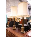A PAIR OF CORINTHIAN STYLE BRASS TABLE LAMPS, with shades, electric, 28" tall without shade, 39"