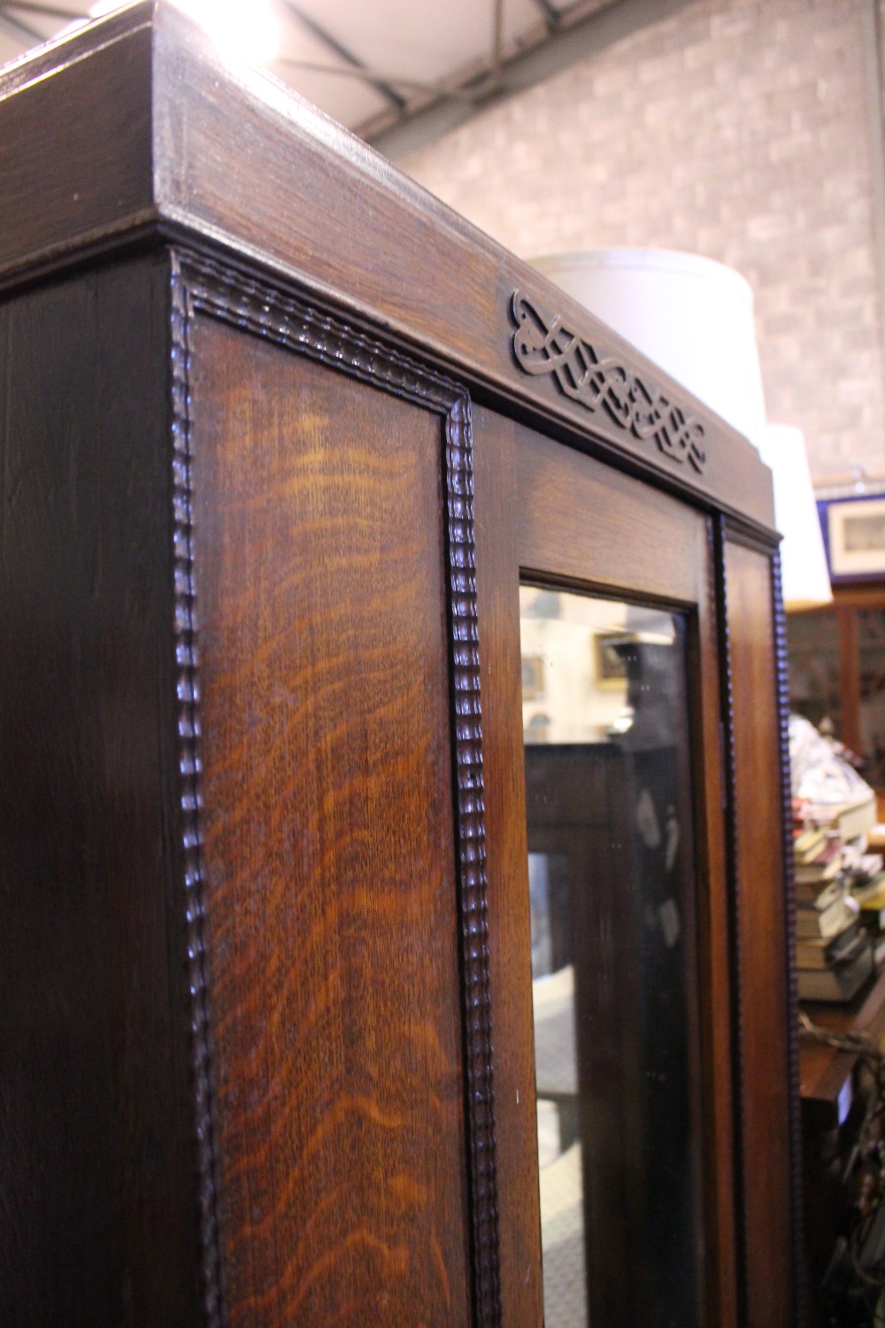 AN EARLY 20TH CENTURY OAK 1 DOOR WARDROBE, with bevelled mirror panel, carved details on a single - Image 2 of 4
