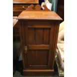 A SINGLE BEDSIDE LOCKER / CABINET, 1 door, with raised swan neck back gallery, on a platform base,