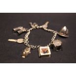 A STERLING SILVER CHARM BRACELET, with various charms, including a pair of shoes, binoculars,