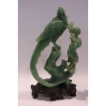 A LARGE DARK GREEN CARVED JADE ORNAMENT, in the form of two birds standing on a tree, one a pheasant