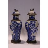 AN EARLY 20TH CENTURY PAIR OF BLUE & WHITE CRACKLE JARS, with lids, each decorated with images of