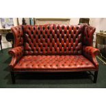 A VERY FINE RED LEATHER BUTTON BACKED COUCH, raised on square reeded frame, with brass beaded