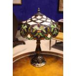 A TIFFANY STYLE TABLE LAMP, with foliage decorated lamp shade, and a fluted shaped base, 19" tall