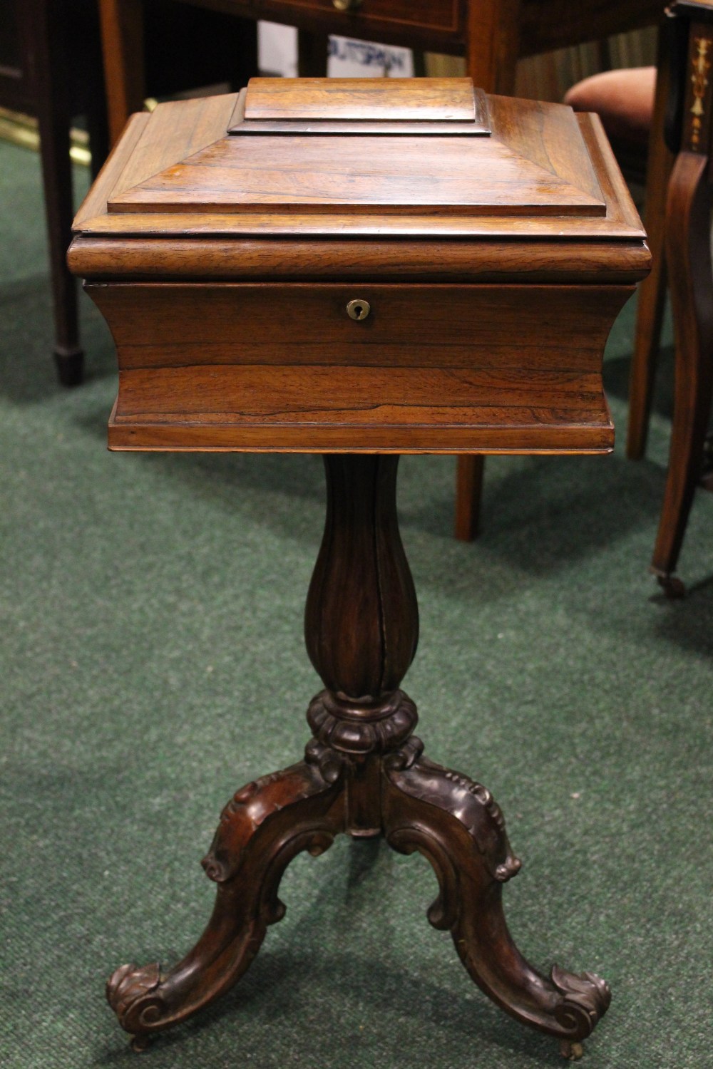 A ROSEWOOD WORK BOX, with concave body, graduated tapered lid, raised on fluted baluster shaped