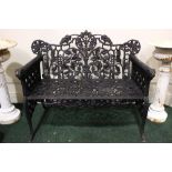 A PAIR OF CAST IRON GARDEN CHAIRS, with ram head arm rests, and foliage design to the back, 43" x