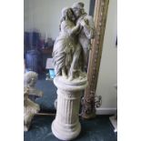 A GARDEN ORNAMENT, in the form of Romeo & Juliet, standing on a column support, 56" tall approx