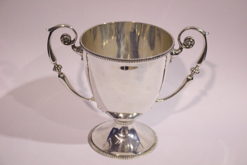 AN EARLY 20TH CENTURY IRISH SILVER TROPHY CUP, with gadrooned rim, two handles with floral detail to