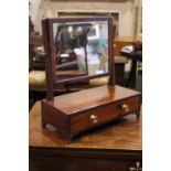 A MAHOGANY TABLE TOP 'SWING' DRESSING MIRROR, with reeded uprights, brass finials, a single drawer