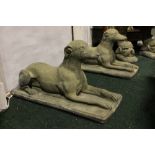 A PAIR OF GARDEN ORNAMENTS IN THE FORM OF GREYHOUNDS LAYING DOWN, 16" x 28" approx