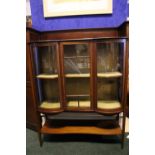 AN EDWARDIAN SERPENTINE SHAPED GLAZED DISPLAY CABINET, with raised inlaid 3/4 gallery, glazed