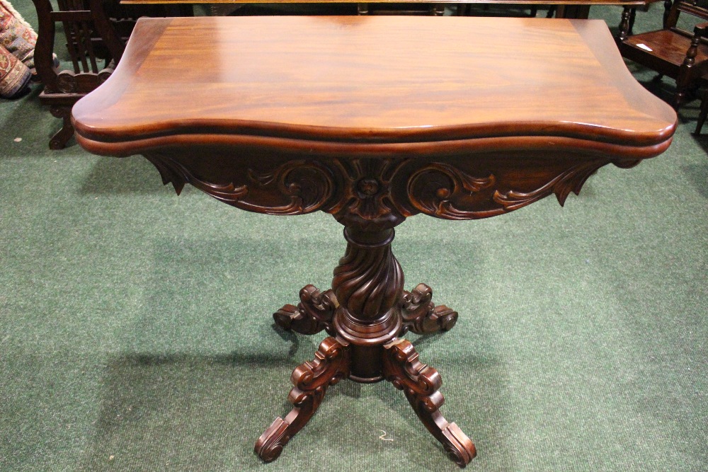 A GOOD QUALITY FOLD OVER CARD TABLE, serpentine shaped, raised on turned and carved column support