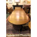 A LARGE THREE POD MAHOGANY EXTENDABLE DINING TABLE, with reeded rim, turned column supports each