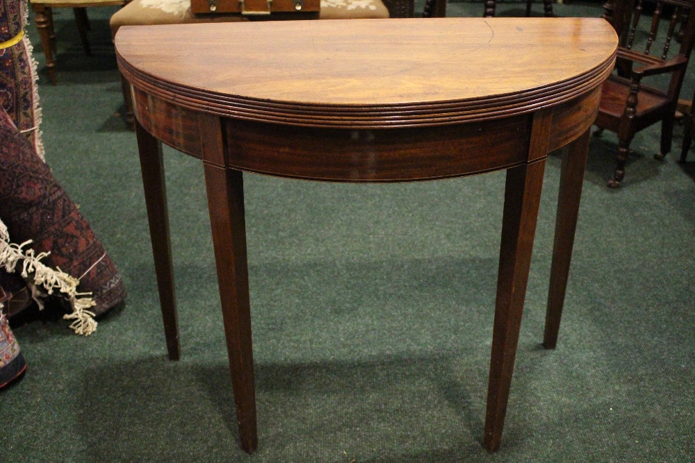 A GOOD QUALITY DEMI-LUNE FOLD OVER CARD TEA TABLE, with reeded rim, raised on tapered leg, having