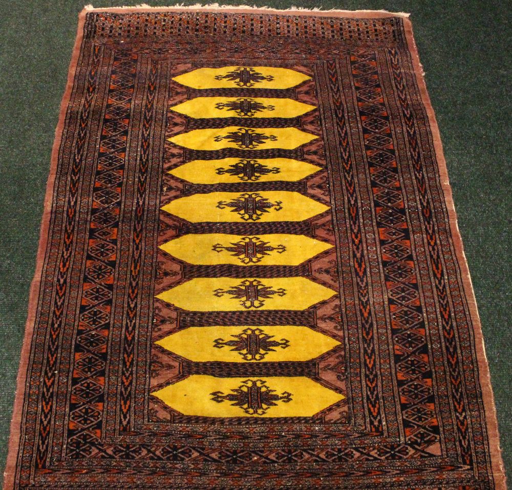 A SMALL FLOOR RUG, with 9 mustard coloured central medallions, multi border, 59" x 37" approx