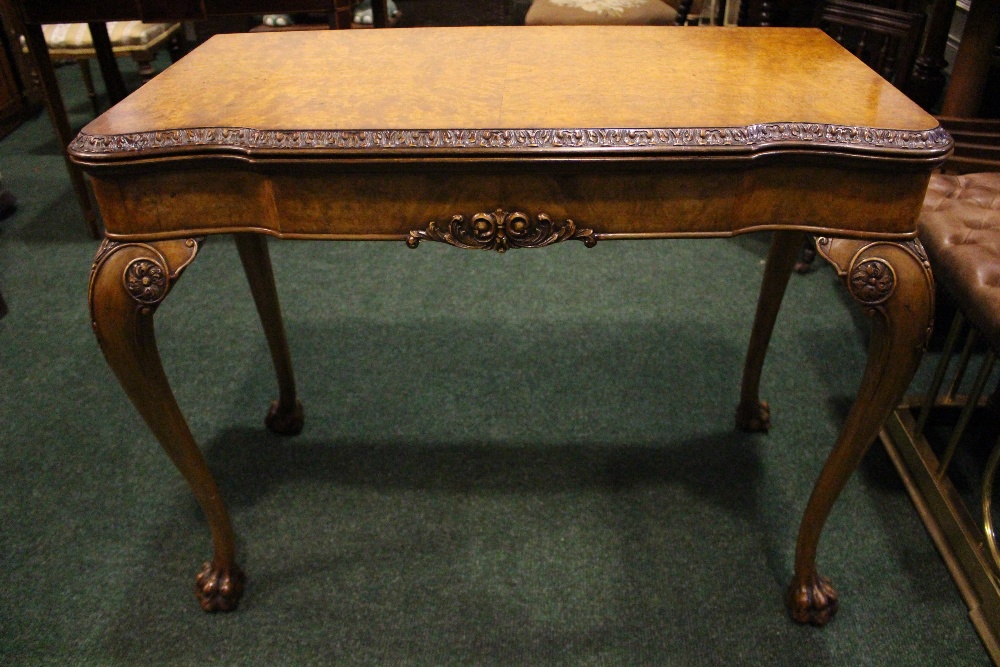 A VERY FINE WALNUT FOLD OVER CARD TABLE, with gadrooned rim of foliage detail, raised on cabriole