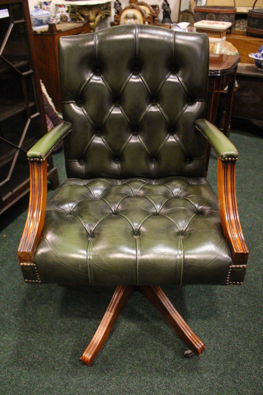 A GREEN BUTTON BACKED LEATHER OFFICE CHAIR, swivel chair, on a four leg base, 39" x 24" x 21"