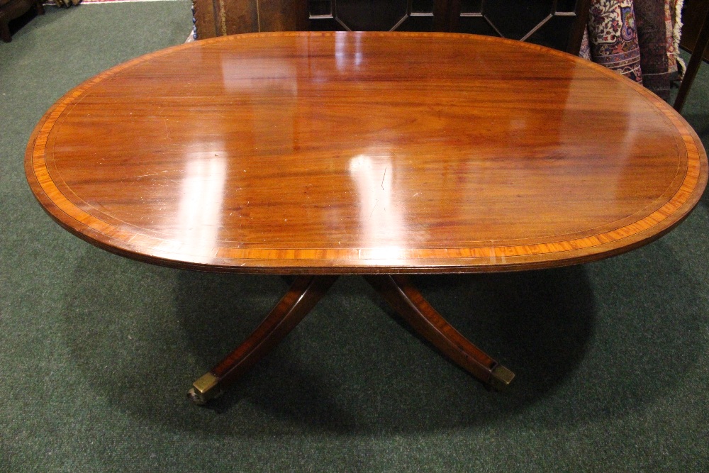 A LOW RISE REGENCY COFFEE TABLE, with crossbanded top, raised on a turned column support with four