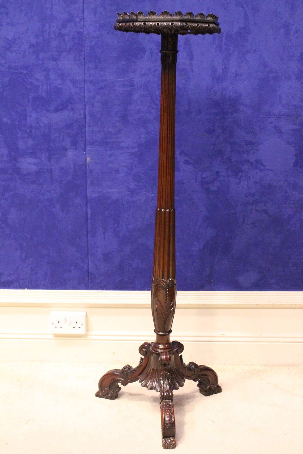A VICTORIAN MAHOGANY TORCHÉRE STAND, with octagonal top having a carved foliage rim, and reeded &