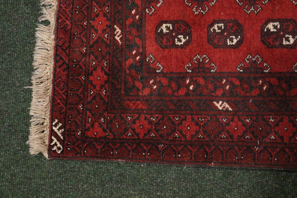 A SMALL FLOOR RUG, with main ground red, multi border, Bokhara style design, 49" x 31" approx - Image 2 of 2