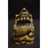 A NETSUKE OF A MAN HOLDING A FISH, 2" tall approx