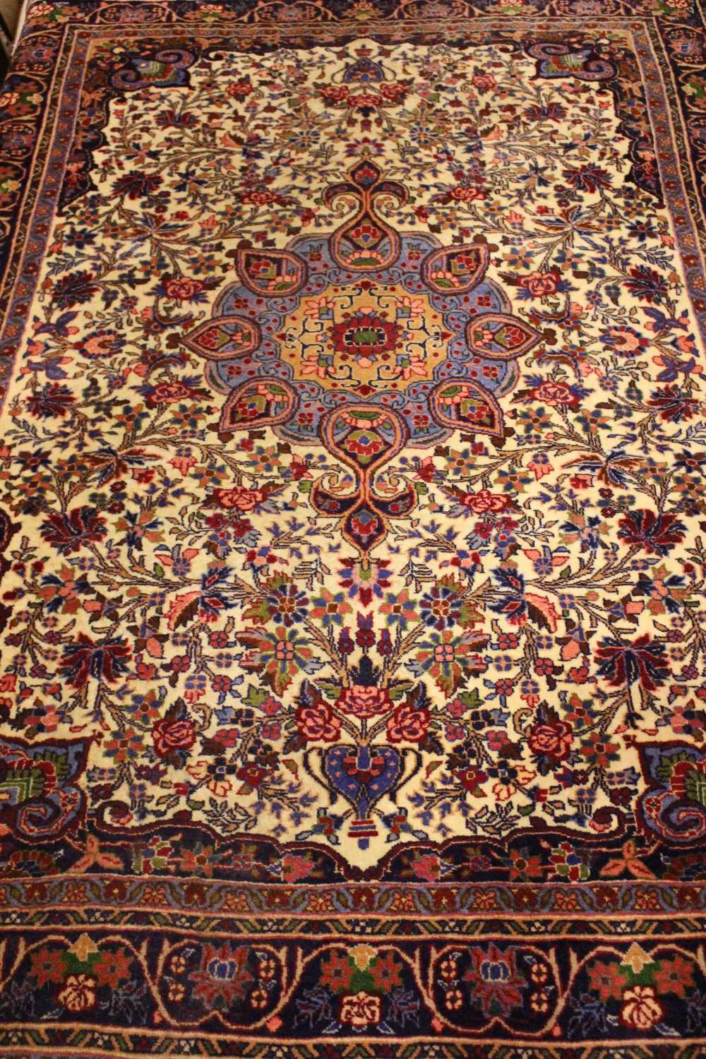 A VERY GOOD QUALITY FLOOR RUG, with central medallion, main central ground cream with red & blue 55"