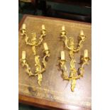 TWO PAIRS OF GILT METAL WALL SCONCES, each with two heads