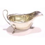 A MID CENTURY SILVER SAUCE BOAT, with scalloped rim and tripod leg, Sheffield, date letter W for