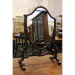 A SHIELD SHAPED TABLE TOP 'SWING' MIRROR, with shaped uprights, and stretcher 21" x 15" x 7" approx