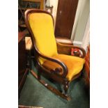 A VICTORIAN MAHOGANY ROCKING CHAIR, with claw and ball leg, carved frame