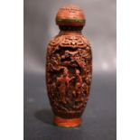 A CARVED CINNABAR & BRASS SNUFF BOTTLE, with inlaid brass character marks to the base, decorated