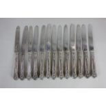 A set of thirteen George IV silver dessert knives with shell and thread handles and engraved