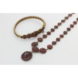 A Bohemian garnet necklace hung from a graduated cluster chain with an oval cluster drop in silver