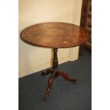 A Sorrento marquetry inlaid table with circular tilting top decorated with flowers and masks, on