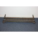 A Victorian cast iron fire fender with pierced decoration, on scroll feet, 96cm