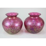A pair of cranberry glass bulbous vases with gold iridescent decoration, 16.5cm