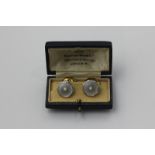 A pair of gold, platinum and mother of pearl cufflinks with a central seed pearl