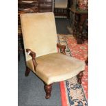 A Victorian upholstered fireside chair on turned front legs and castors