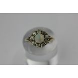 An opal and diamond cluster ring within a border of eigth old cut diamonds