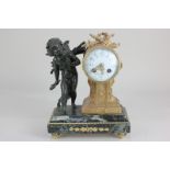 A gilt metal figural mantel clock with 8cm dial in drum shaped case with trophy surmount flanked