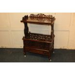 A Victorian walnut Canterbury whatnot with pierced fretwork and rectangular shelf above a three