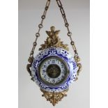 A French gilt metal mounted blue and white pottery wall clock, circular form with 11cm dial, in blue