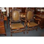 A pair of Carolean style carved oak armchairs with oval padded backs and ornately carved surround of