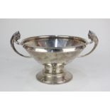 An Art Deco silver circular pedestal bowl with two lion head cast handles, on stepped circular base,
