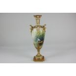 A Royal Worcester porcelain twin-handled vase decorated with a view of storks beside water, signed A